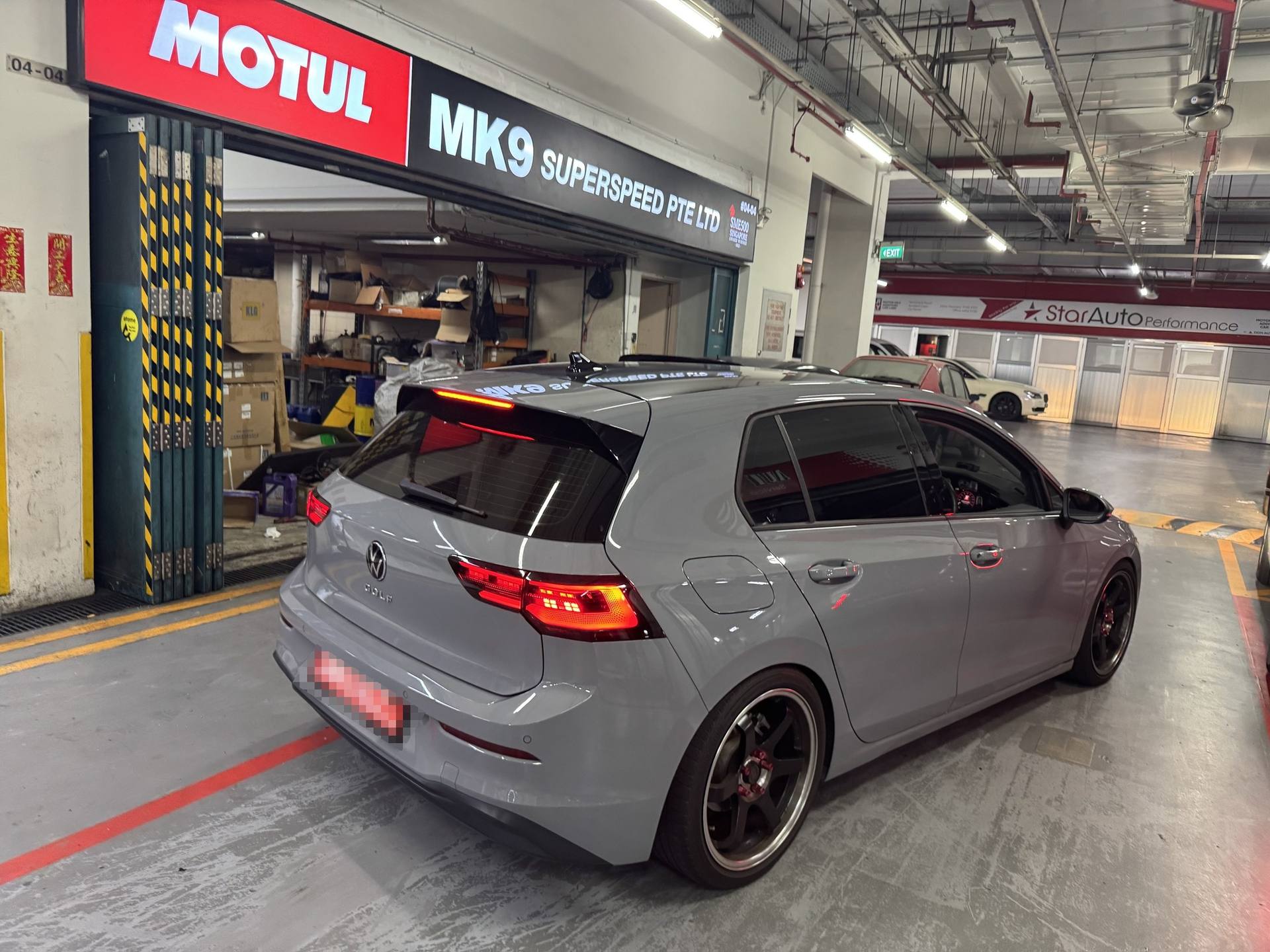 Grey Golf GTI Mk8 at the MK9 workshop entrance