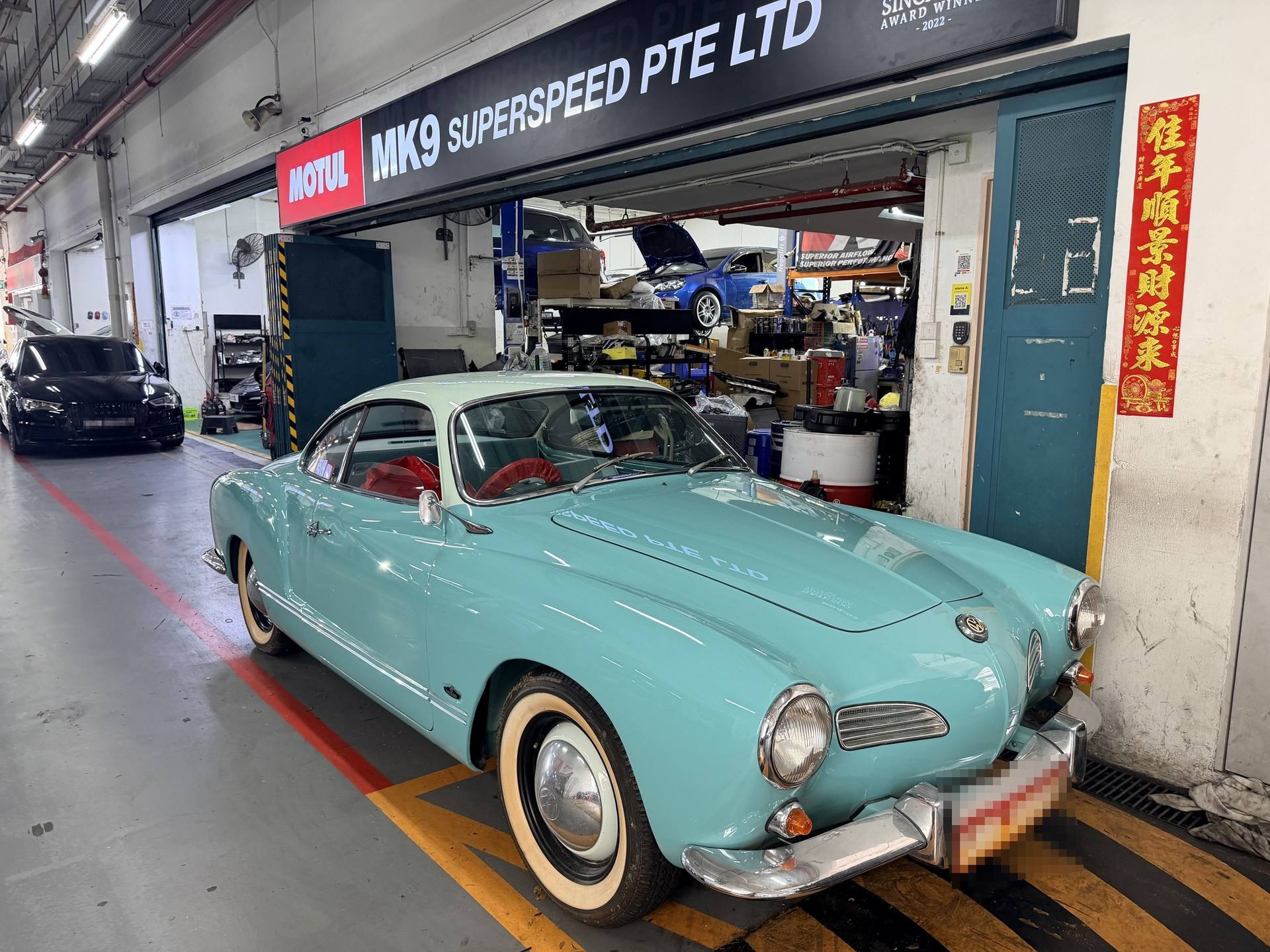 Classic teal Volkswagen Karmann Ghia outside the MK9 workshop
